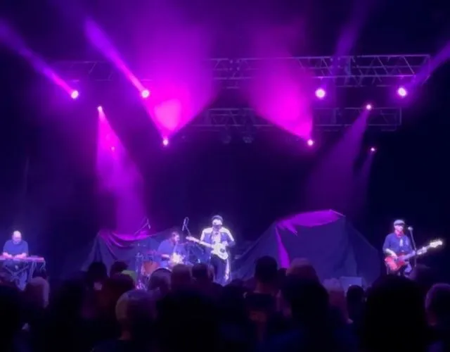From the crowd at Bayou Music Center: a purple-lit stage with keys at the far left, drums, Paco Estrada at centre and Brandon Callies on bass.